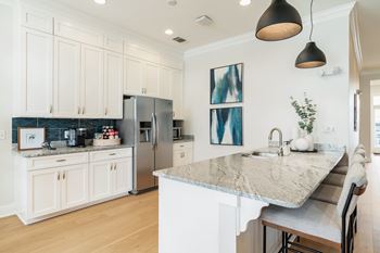 A kitchen with a marble countertop and stainless steel appliances.